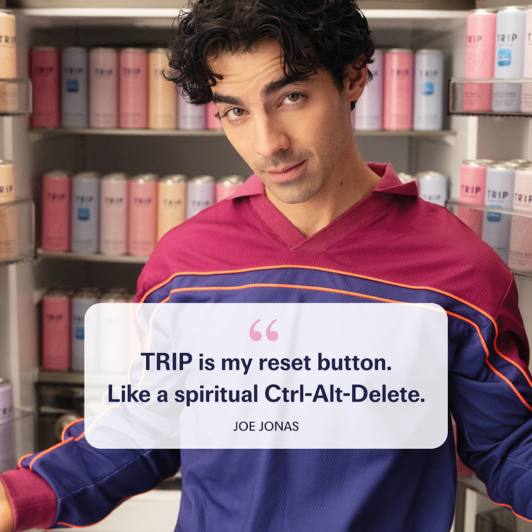 Man in colorful jacket holding a sign with a quote about TRIP, in a store setting.